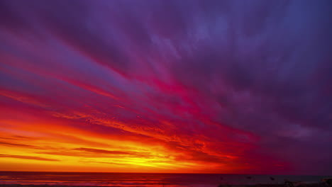 Cielo-Rojo-Ardiente-Reflejado-En-La-Superficie-Del-Mar-En-Verano-Durante-La-Puesta-De-Sol