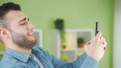 un joven feliz volviendo a casa enviando mensajes de texto por teléfono, feliz y emocionado.