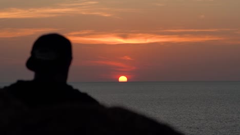 hombre viendo la puesta de sol en el cabo promthep, phuket