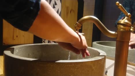 man washing hands with soap in a fancy restaurant 4k