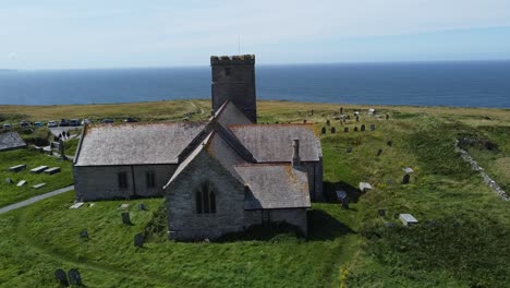 St-Materiana&#39;s-Church-In-Tintagel-Cornwall-Mit-Blick-Auf-Die-Sonnige-Meerseite-Und-Die-Klippen-Mitten-Am-Tag-Im-Sommer,-Die-Aufnahme,-Die-Ich-Verwendete,-Ist-Eine-Stativaufnahme-Mit-Einer-Drohne-Und-Sie-Wurde-In-1080p-Fhd-Aufgenommen