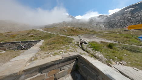 fpv drone follows two mountain bikers descending steep, exposed alpine trails above saas-grund and saas-fee on a clear bluebird summer day, showcasing epic terrain and speed