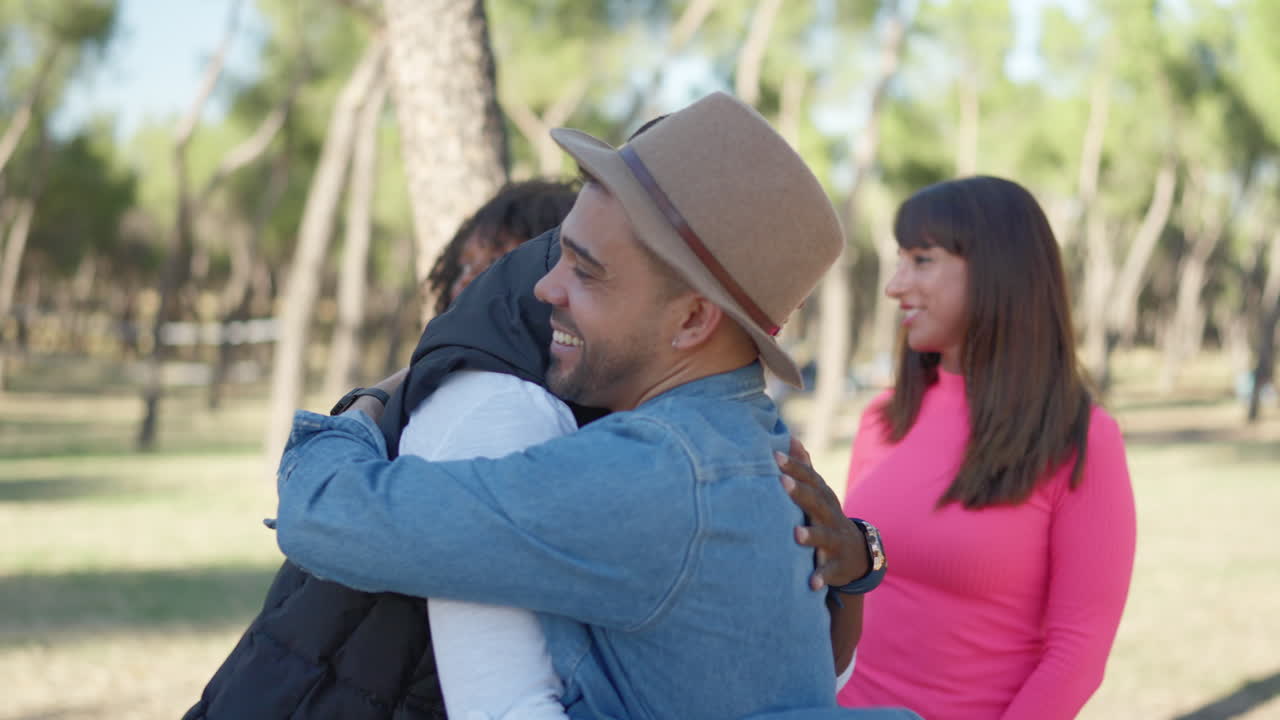 Diverse group of friends greeting and hugging in a park