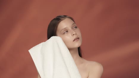 woman drying her face with a towel