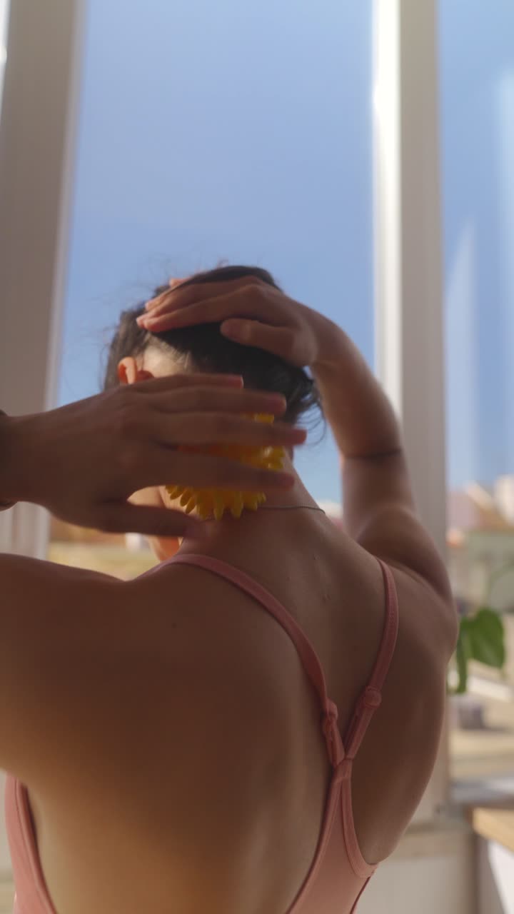 Donna che si massaggia il collo con una palla da massaggio