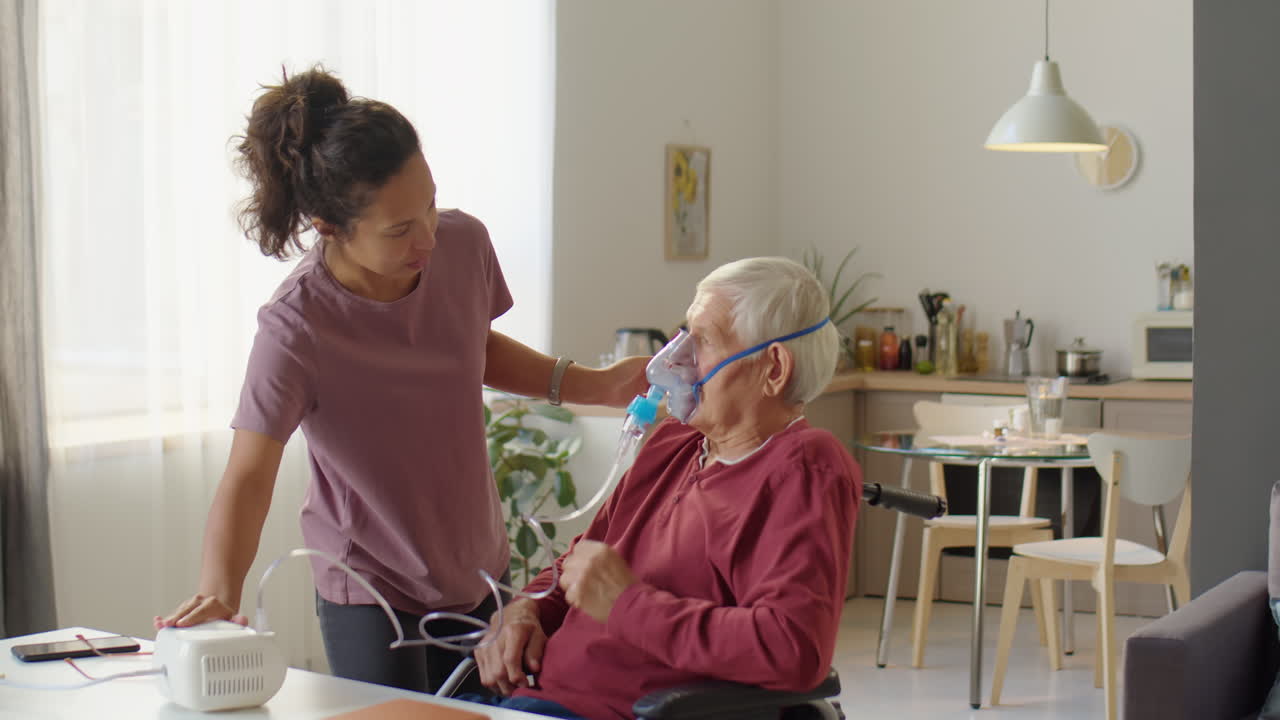 Caregiver Helping elderly Man to Use Nebulizer