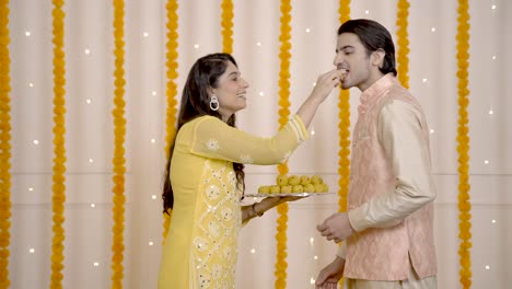 pareja india comiendo dulces en diwali