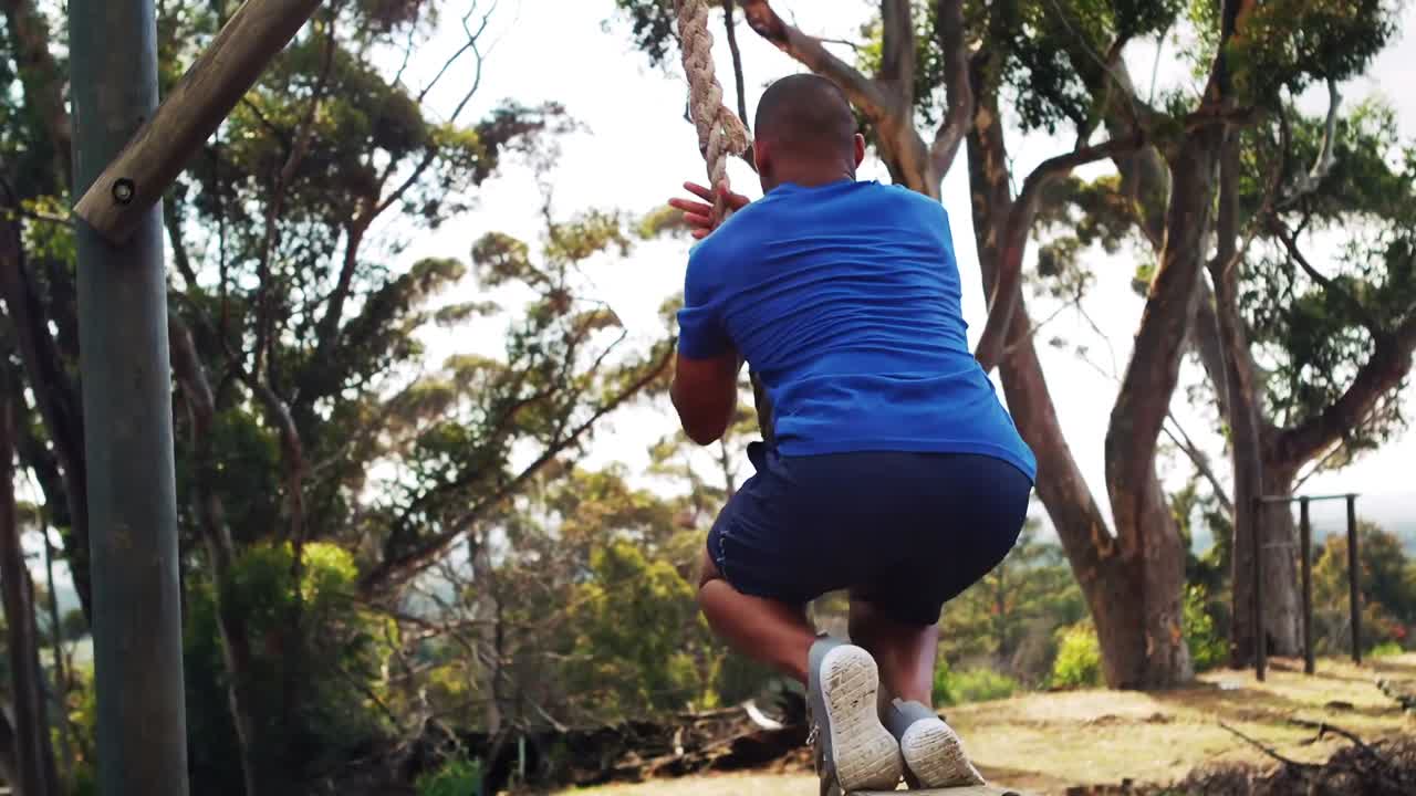 Man climbing down  the rope during obstacle course
