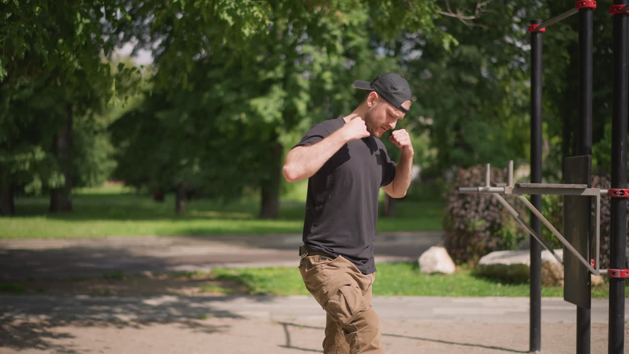 White Man Warming Up At Outdoor Gym With Dynamic Arm Movements And Light Stretches, Preparing For Calisthenics Routine On Metal Bars, Sunny Park Environment And Casual Athletic Wear