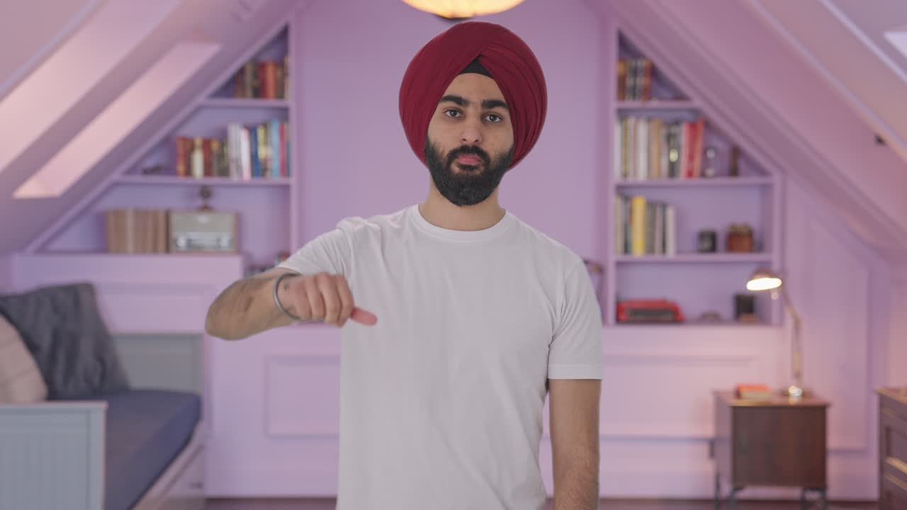 Uomo indiano Sikh deluso che mostra il pollice verso il basso
