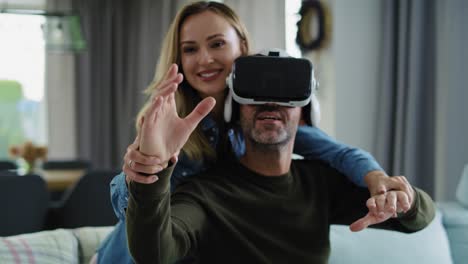 Modern-couple-using-virtual-reality-simulator-in-living-room