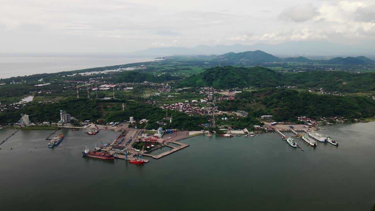 amplia vista del barco de transporte de contenedores de carga y los transbordadores estacionados en el puerto de poto tano puerto sumbawa indonesia, silueta puesta de sol