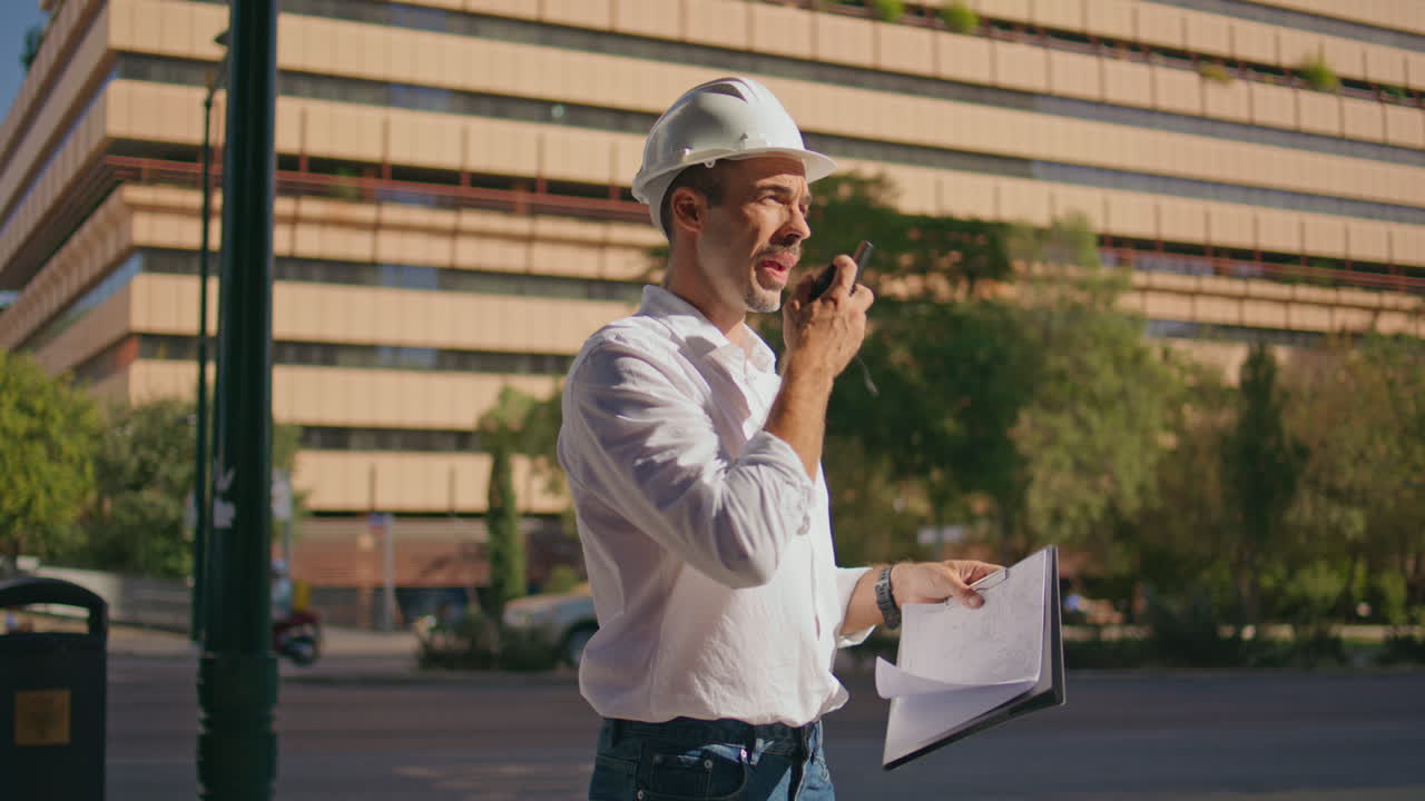 Focused engineer checking building plan at sunbeams city closeup. Man working