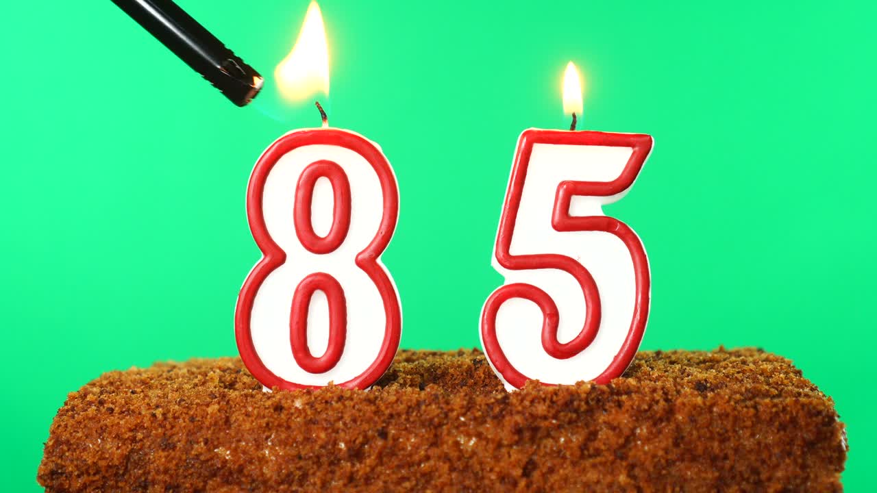 pastel con el número 85 vela encendida. llave de croma. pantalla verde. aislado
