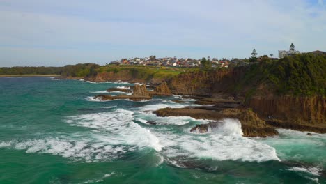 turquoise sea with waves crashing to shore in jones beach, nsw australia - aerial shot