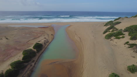 Spiaggia-di-Piscinas,-Sardinia:-flying-over-the-canals-that-join-the-sea-on-this-beautiful-beach-on-the-island-of-Sardinia