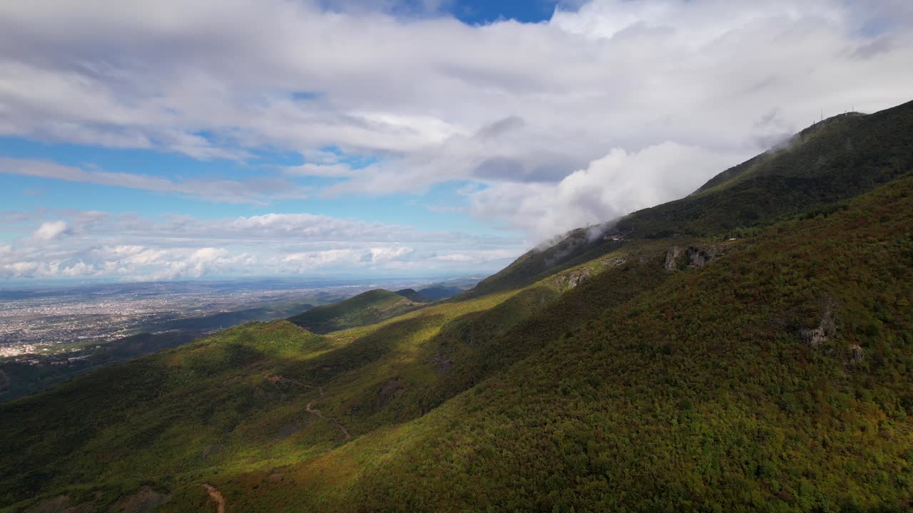 paisaje montañoso panorámico en otoño con bosque verde y nubes sobre el fondo de la ciudad