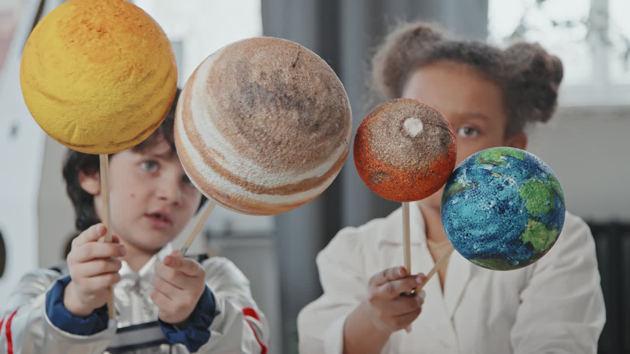 Little Boy and Girl Holding Models of Planets