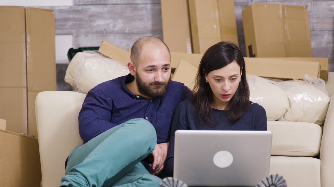 Couple using laptop after moving in
