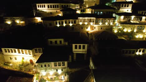 berat mangalem neighborhood houses at night with illuminated windows and verandas, welcoming tourists to guest houses and hotels