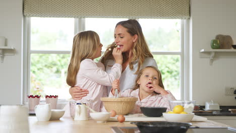 Mutter-Und-Zwei-Töchter-Im-Schlafanzug-Backen-Gemeinsam-In-Der-Küche-Zu-Hause