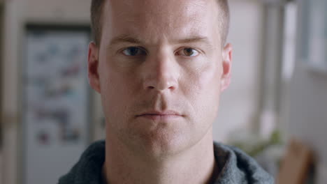 portrait-attractive-man-looking-at-camera-with-serious-expression-at-home