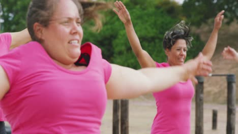 Female-friends-enjoying-exercising-at-boot-camp-together