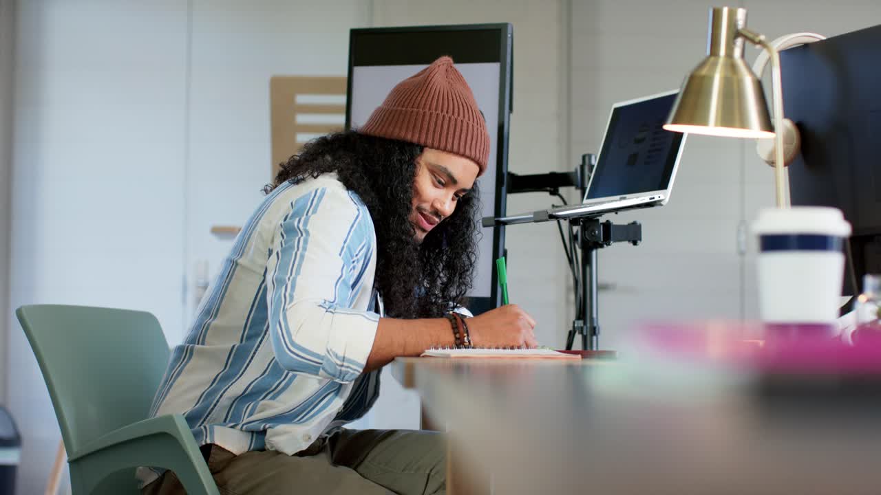 Mid adult man at office reviewing monitor graphic, adjusting stand, writing notes with green marker