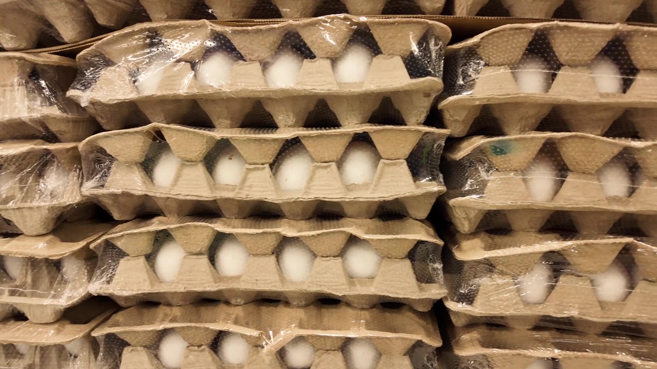 Gestapelte Kartons mit frischen weißen Eiern im Supermarkt