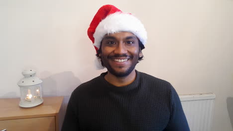 Young-Man-On-Christmas-Video-Call-Listening-Intently-Whilst-Looking-to-Camera