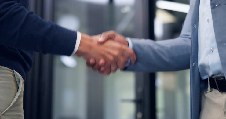Due professionisti d'affari che si stringono la mano in un ufficio moderno