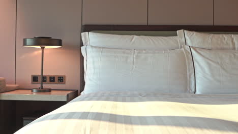 tilt-down from headboard to multiple pillows lined up on a hotel suite bed