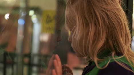 little kid taking offence to somebody and leaning to the glass
