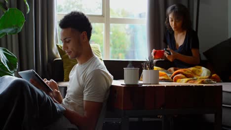 side view of young asian man using digital tablet in living room at home 4k