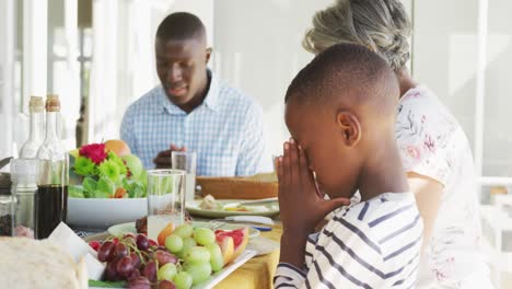 Video-Einer-Afroamerikanischen-Familie,-Die-Vor-Dem-Essen-Gemeinsam-Betet