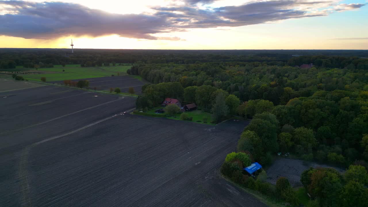 farmhouse surrounded by plowed fields, a forest, and a road in germany. Great aerial view flight panorama overview drone