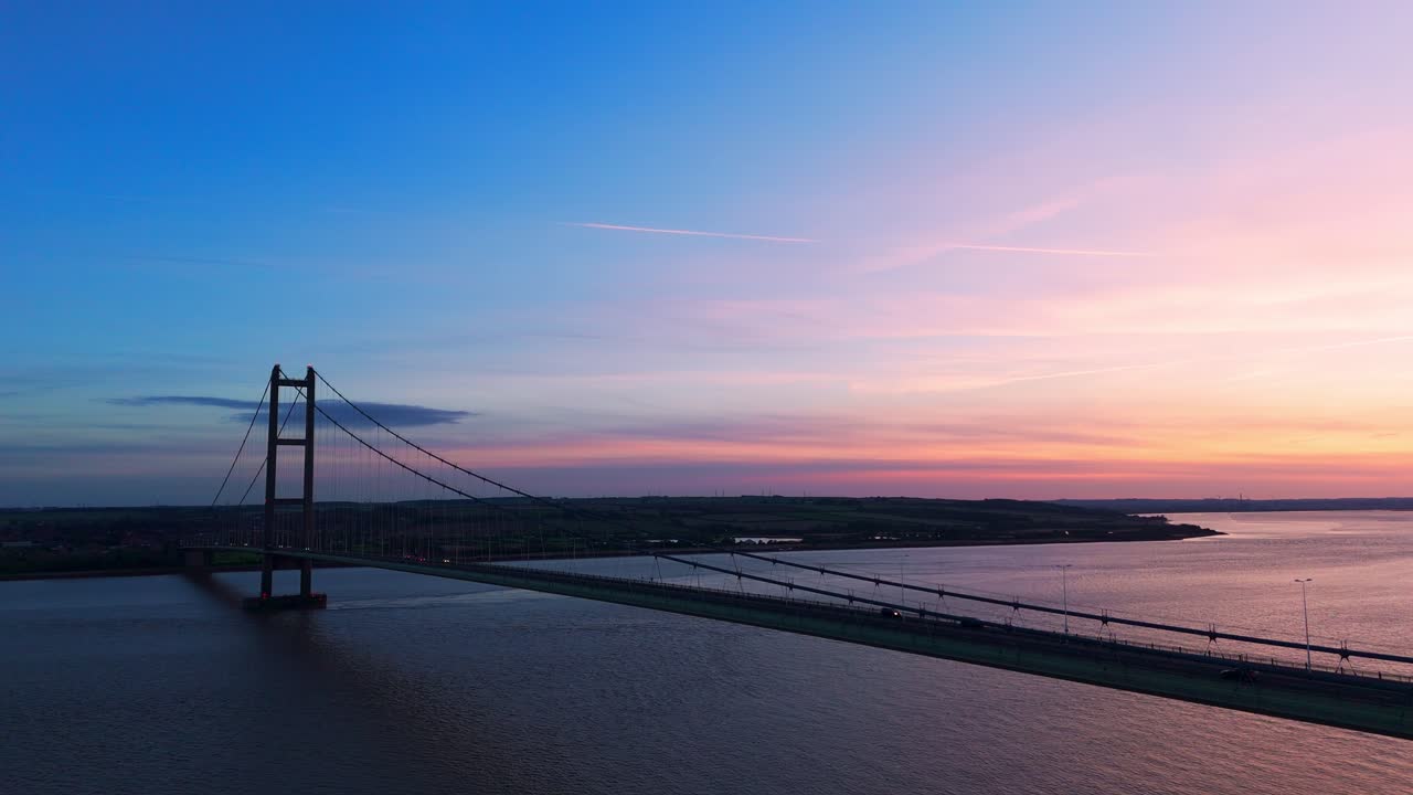 Sunset's charm: Aerial view of Humber Bridge with cars in graceful, synchronized motion