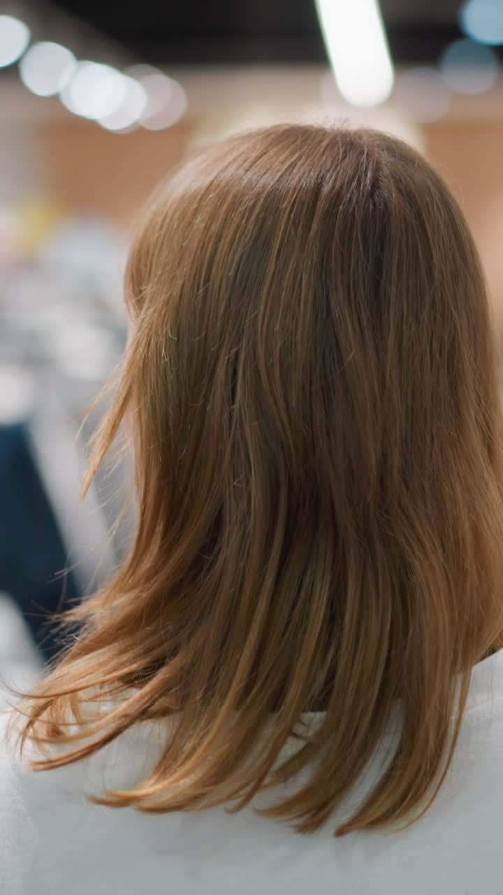 옷 가게 를 가로질러 고 있는 쇼핑객 의 뒷면 을 보면서 오른쪽 과 왼쪽 을 들여다보며, 부드럽게 흐릿 한 배경 에 있는 세련 된 의류 의 크 로 둘러싸여 있다