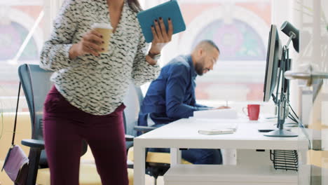 mixed race team of young business people working in open plan office desk rows of computers in shared workspace bright natural light