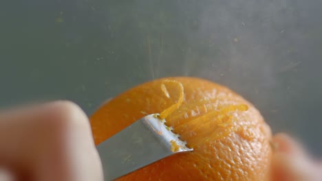 close-up of orange zest being grated with a zester