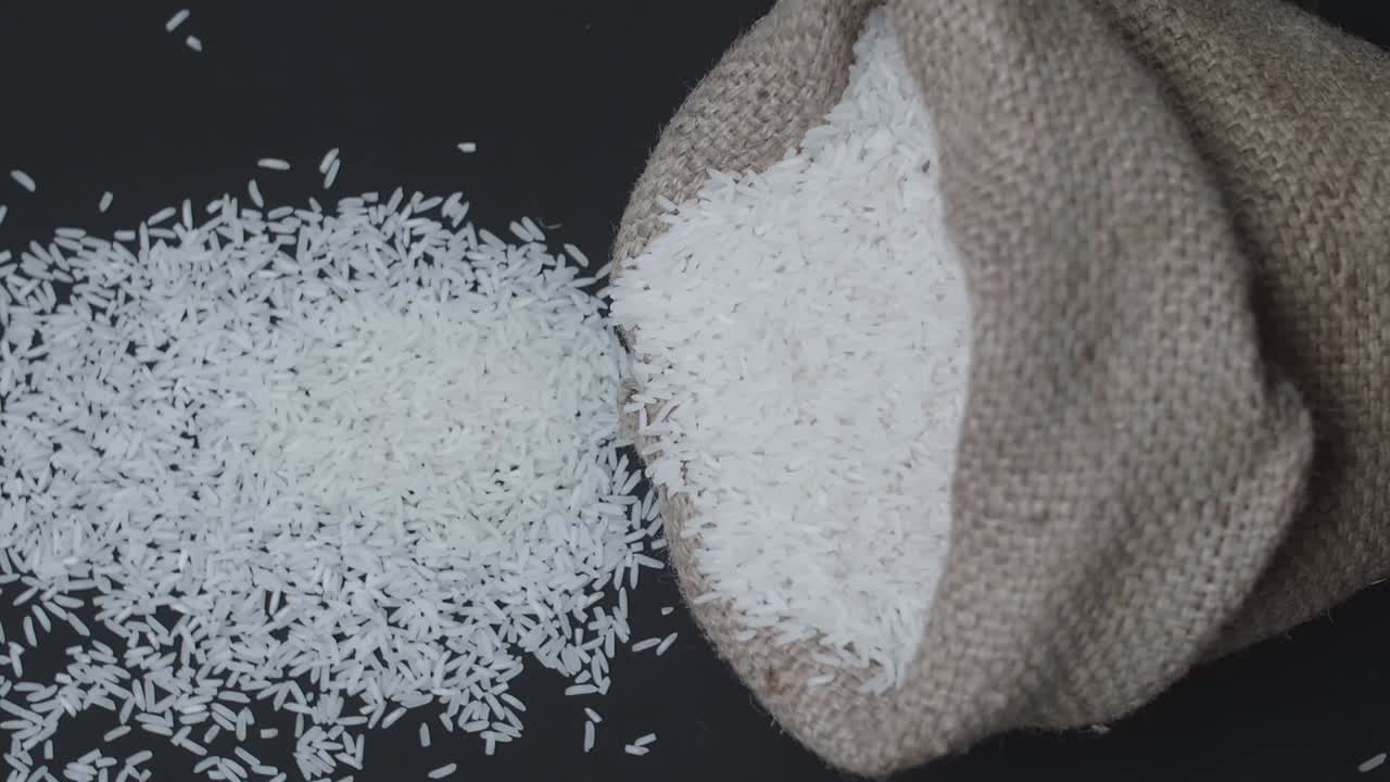 Slow Motion Rice Pours Out Of Falling Sack On Black Table