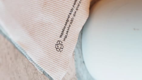 close-up of a fabric product highlighting its 100% recycled fiber content and recycling symbol