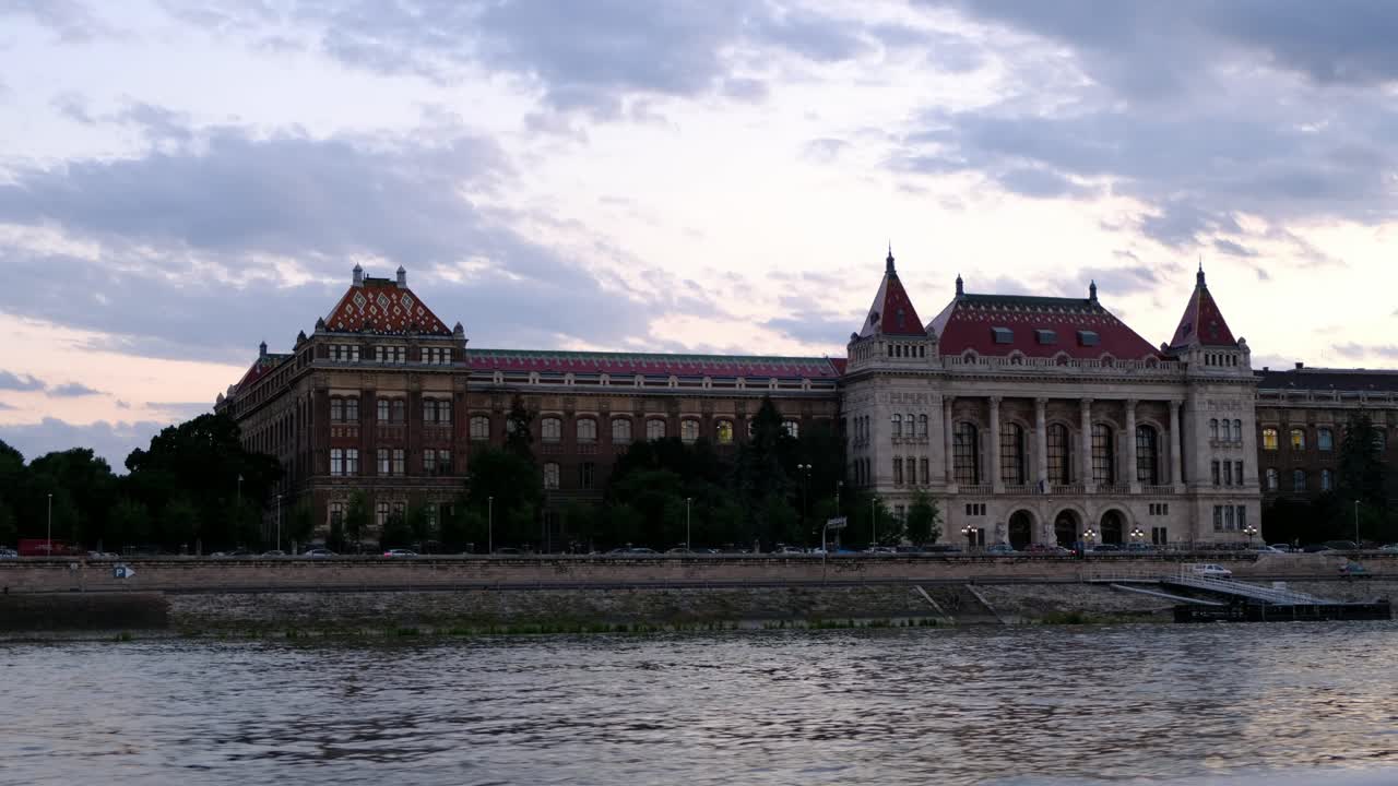 toma cinematográfica del edificio bme de la universidad de tecnología y economía de budapest en la hora dorada, tomada desde el río danubio en budapest, hungría