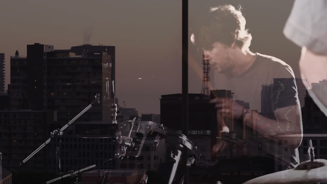 Chitarrista che inizia un riff, batterista che si unisce al ritmo e crea un groove rock contro uno skyline crepuscolare.
