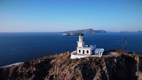 disparo de un dron en órbita circular del faro de santorini durante la puesta de sol