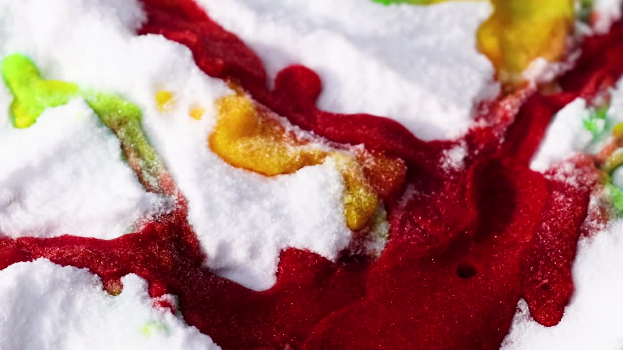 Close-up of a colorful reaction with red, yellow, and green on a white textured background.