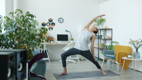man doing yoga archer's pose at home