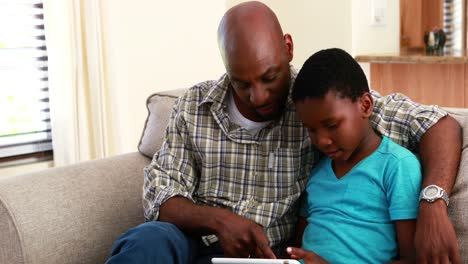 padre e hijo usando tableta digital en la sala de estar 4k