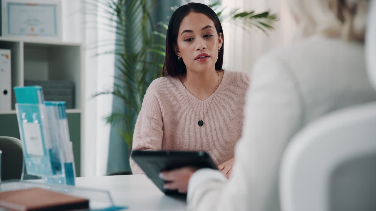 A female doctor talking to a patient in her office