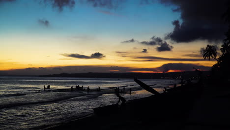 Silueta,-Hombres-Sacando-La-Red-De-Pesca-De-La-Playa-Del-Océano-Durante-La-Puesta-De-Sol